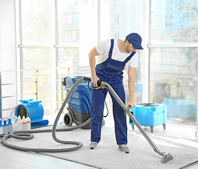 Man Cleaning Carpet with Vacuum Cleaner